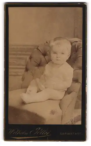 Fotografie Wilhelm Pöllot, Darmstadt, Portrait niedliches Kleinkind im weissen Hemd auf Sessel sitzend