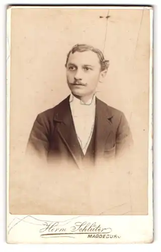 Fotografie Herm. Schlüter, Magdeburg, Portrait junger Mann im Anzug mit Fliege