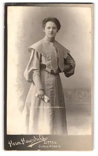 Fotografie Herm. Hauschild, Zittau, Portrait junge Dame im modischen Kleid mit Handschuhen