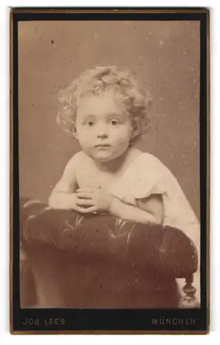 Fotografie J. Leeb, München, Portrait niedliches Kleinkind im weissen Hemd auf Sessel stehend