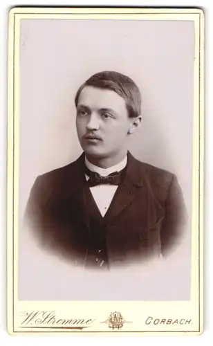 Fotografie W. Stremme, Corbach, Portrait junger Herr im Anzug mit Fliege