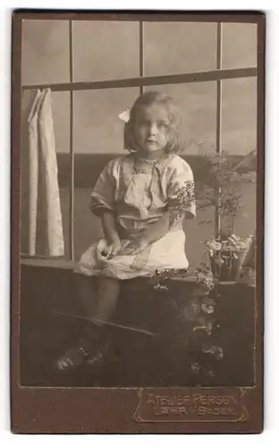 Fotografie Atelier Person, Lahr i. Baden, Portrait blondes süsses Mädchen im Kleidchen auf einer Fensterbank sitzend