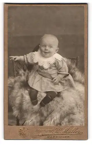 Fotografie K. Müller, Memmingen, Portrait lächelndes Kleinkind mit Pausbacken