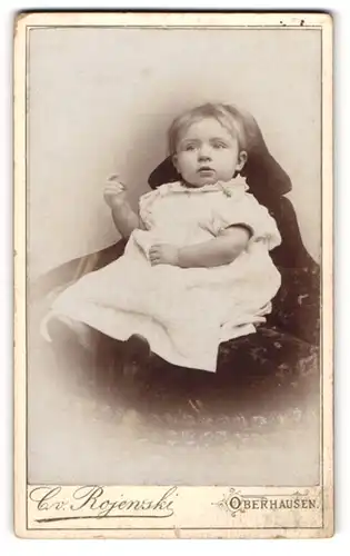 Fotografie C. v. Rojenski, Oberhausen, Portrait niedliches Kleinkind im langen weissen Kleid