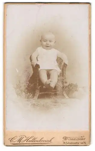 Fotografie C. M. Hellenbroich, Düsseldorf, Portrait niedliches Baby im weissen Hemd auf Stuhl sitzend