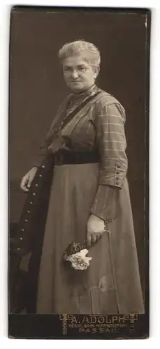 Fotografie A. Adolph, Passau, Portrait ältere Dame mit Brille und Blumen an Stuhl gelehnt