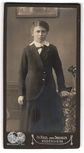 Fotografie Fr. Riedl vorm. Drechsler, Rosenheim, Portrait junge Dame in modischer Kleidung an Tisch gelehnt