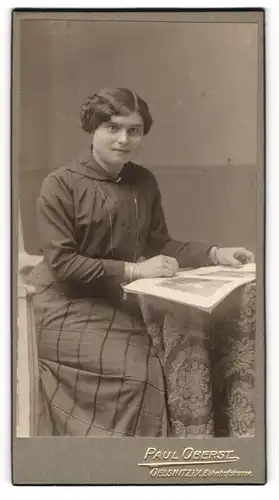 Fotografie Paul Oberst, Oelsnitz i. V., Portrait bürgerliche Dame mit Zeitung am Tisch sitzend