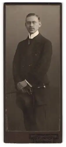 Fotografie G. Klimmer, Bückeburg, Portrait junger Herr im eleganten Anzug mit Hut und Stock