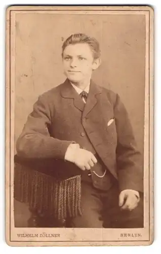 Fotografie Wilhelm Zöllner, Berlin, Portrait lächelnder Bursche im Anzug