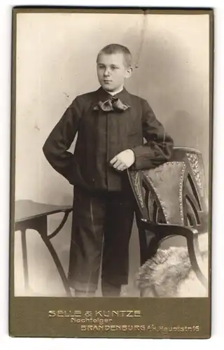 Fotografie Selle & Kuntze Nachf., Brandenburg a/H., Portrait Knabe in kurzen Hosen eine Schleife zur Jacke tragend