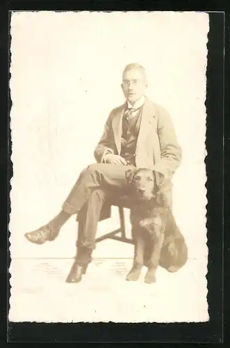 Foto-AK Elegant gekleideter Mann auf Hocker sitzend mit Hund