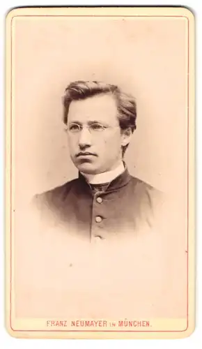 Fotografie Franz Neumayer, München, Portrait junger Geistlicher mit Brille in Talar