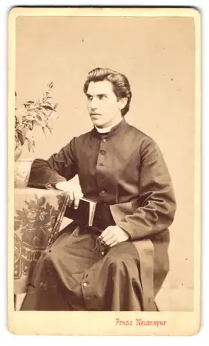 Fotografie Franz Neumayer, München, Portrait Pastor mit Bibel am Tisch sitzend