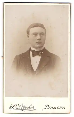 Fotografie P. Stecher, Pyrmont, Portrait junger Herr in Anzug mit Fliege