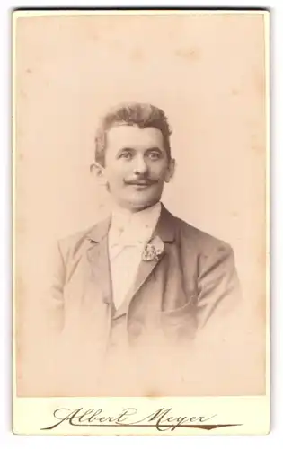 Fotografie Albert Meyer, Berlin, Portrait charmant blickender Mann mit Ansteckblume am Jackett