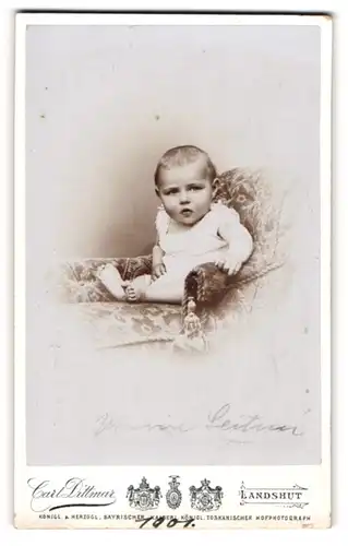 Fotografie Carl Dittmar, Landshut, Portrait bezauberndes Kleinkind in einem Sessel sitzend