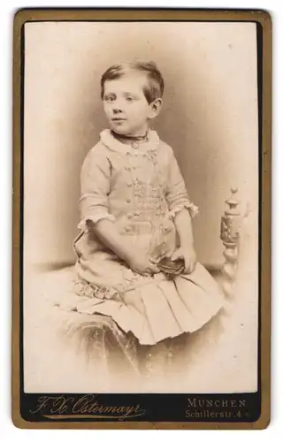 Fotografie F. X. Ostermayr, München, Portrait kleines Mädchen im hübschen Kleid mit Büchlein auf Tisch sitzend