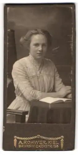 Fotografie A. Rohwer, Kiel, Portrait junges Mädchen mit Buch am Tisch sitzend