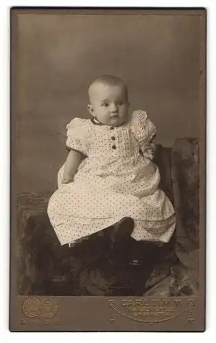 Fotografie Carl Timm, Harburg a / Elbe, Portrait niedliches Baby im gepunkteten Kleid