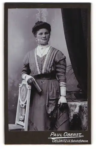 Fotografie Paul Oberst, Oelsnitz i. V., Portrait bürgerliche Dame mit Buch an Stuhl gelehnt