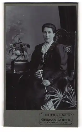 Fotografie German Gober, Braunau a. Inn, Portrait bürgerliche Dame mit Schirm am Tisch sitzend