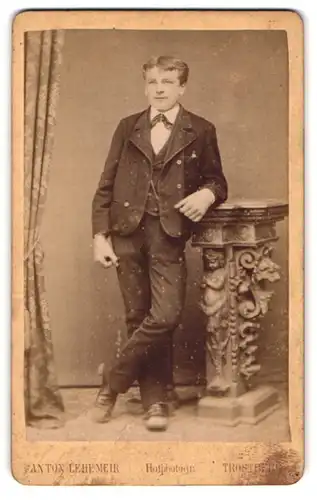 Fotografie Anton Lehemeir, Trostberg, Portrait junger Mann in modischer Kleidung an Sockel gelehnt
