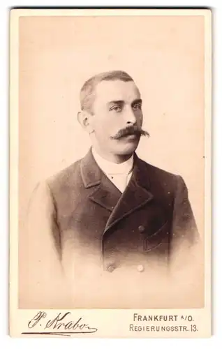Fotografie P. Krabo, Frankfurt O., Mann mit Schnauzer und geknüpfter Jacke im Portrait