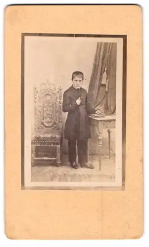 Fotografie unbekannter Fotograf und Ort, Knabe mit Mantel in Napoleon Haltung