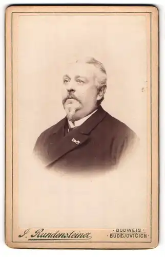 Fotografie J. Rundensteiner, Budweis, Portrait korpulenter Herr mit Reversnadel am Jacket
