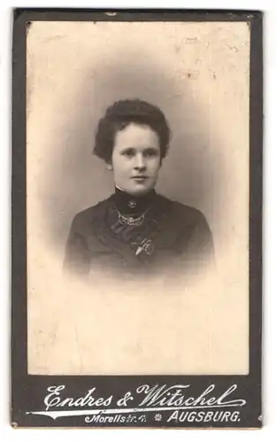 Fotografie Endres & Witschel, Augsburg, Portrait junge Dame im schwarzen Kleid mit Halskette