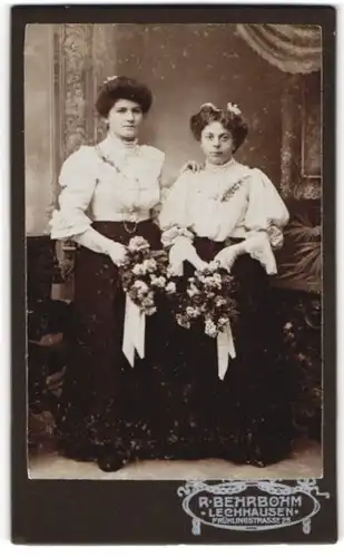 Fotografie R. Behrbohm, Lechhausen, Portrait zwei junge Damen in weissen Blusen mit Blumensträussen