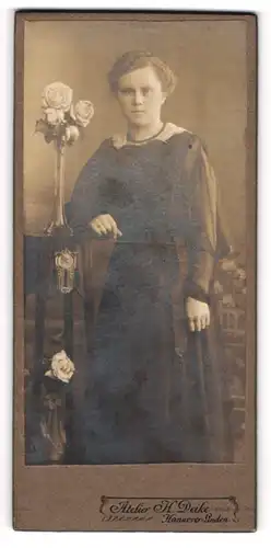 Fotografie H. Deike, Hannover-LInden, Portrait junge Dame im eleganten Kleid an Tisch gelehnt