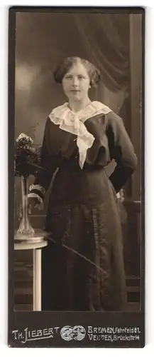 Fotografie Th. Liebert, Bremen, Portrait bürgerliche Dame mit Blumen an Tisch gelehnt