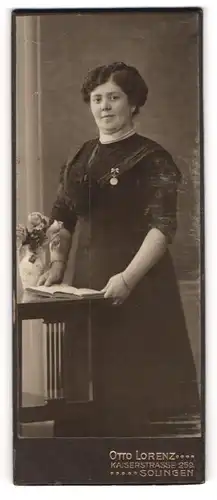 Fotografie Otto Lorenz, Solingen, Portrait bürgerliche Dame mit Buch an Tisch gelehnt