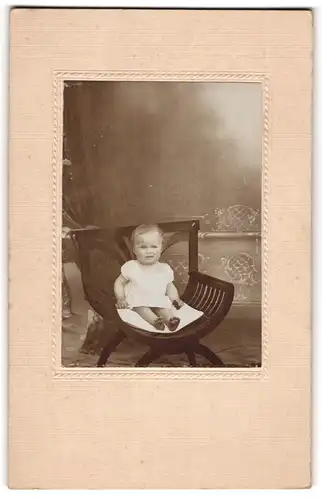 Fotografie unbekannter Fotograf und Ort, Portrait niedliches Kleinkind im weissen Hemd mit nackigen Füssen