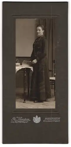 Fotografie X. Simson, Rosenheim, Portrait bürgerliche Dame mit Zeitung an Tisch gelehnt