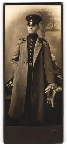 Fotografie C. Axtmann, Plauen i. Sa., Portrait Soldat im Uniformmantel mit Schirmmütze und Handschuhen
