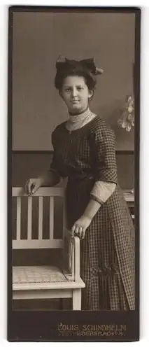 Fotografie Louis Schindhelm, Ebersbach i / S., Portrait junge Dame im karierten Kleid an Bank gelehnt