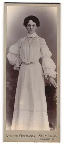 Fotografie Atelier Germania, Strausberg, Portrait junge Dame in heller Kleidung an Tisch gelehnt