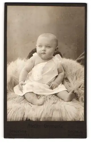 Fotografie Atelier Germania, Strausberg, Portrait niedliches Baby im weissen Hemd auf Fell sitzend