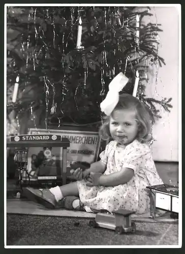 Fotografie Kleinkind bei Bescherung mit Schokoladeverschmiertem Mund, Weihnachten, Spielzeug-Tankstelle