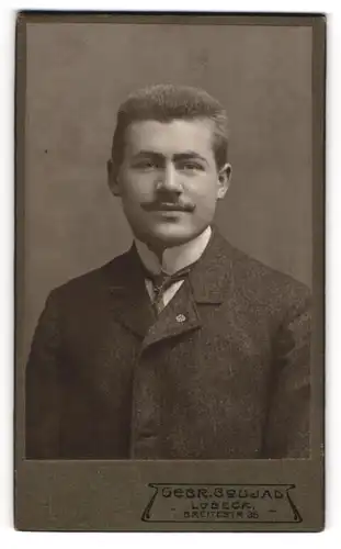 Fotografie Gebr. Coujard, Lübeck, Portrait Herr August Stein im Anzug mit Mustasch, 1907