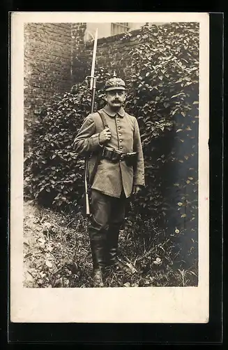 Foto-AK preussischer Soldat in Uniform mit Filz-Ersatzpickelhaube, Gewehr mit Bajonett