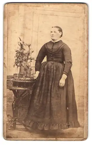 Fotografie unbekannter Fotograf und Ort, Portrait hübsch gekleidete Dame an Tisch gelehnt