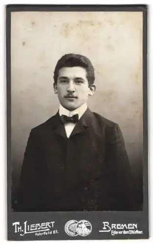 Fotografie Th. Liebert, Bremen, Portrait dunkelhaariger junger Mann in Fliege und Jackett