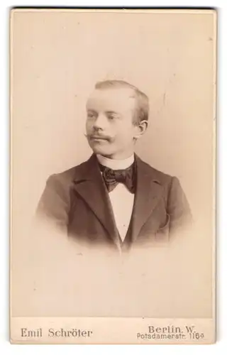 Fotografie Emil Schröter, Berlin-W, Portrait junger Herr in Anzug mit Fliege