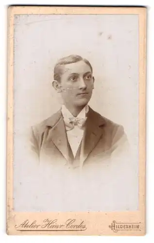 Fotografie Heinr. Cordes, Hildesheim, Portrait junger Mann in Fliege und Jackett