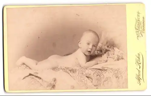 Fotografie Alfred Hahn, Magdeburg, Portrait süsses Baby auf einer bestickten Decke liegend