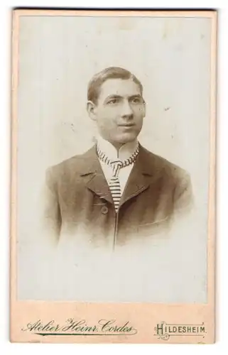 Fotografie Heinr. Cordes, Hildesheim, Portrait charmanter junger Mann in gestreifter Krawatte